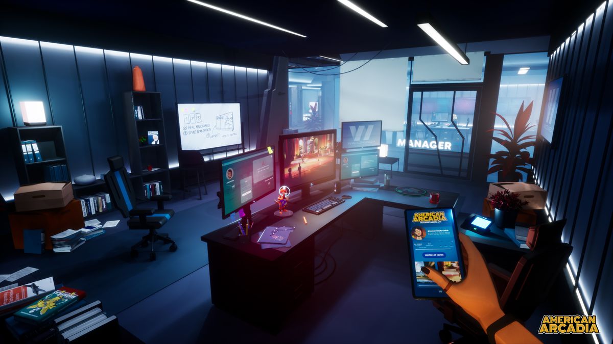 Inside an office, there are several computer screens lit up. In the bottom right-hand corner of the screen, there’s a hand holding a cellphone.